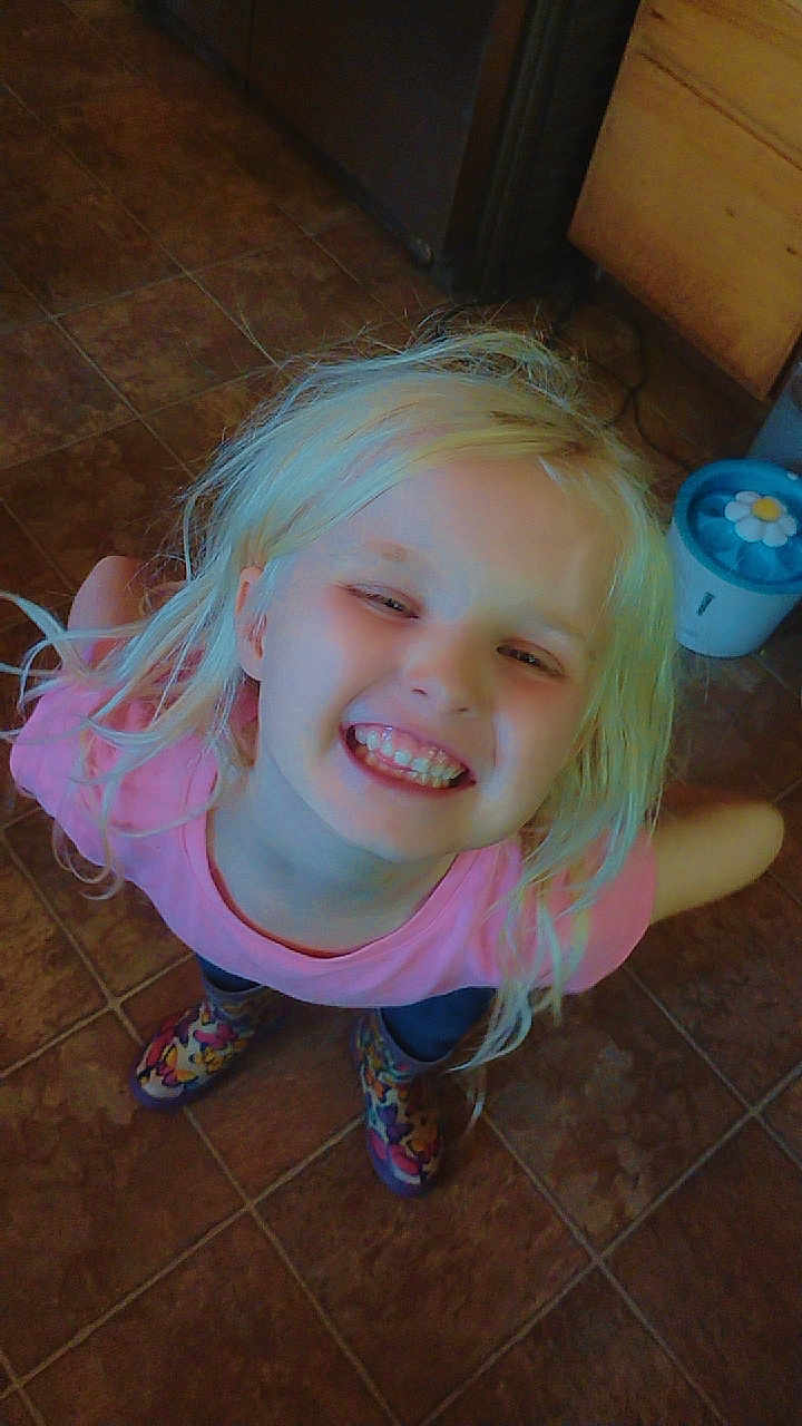 Hailey joined the competition — help win amazing prizes! child, smiling, blonde_hair, pink_shirt, colorful_shoes, tile_floor, happy, standing, indoor, person, face, cute, joyful, casual_clothing, young, playful, portrait, looking_up, fun, light_hair