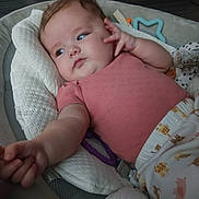Elenora is registered to the contest to win money with this photo: baby, infant, child, pink_shirt, blanket, toy, cushion, face, hand, indoor, comfort, sleepy, cute, young_child, clothing, lying_down, soft_toys, home, portrait, relaxed