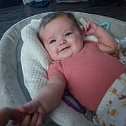 Elenora joined the competition — help win amazing prizes! baby, smile, infant, cushion, hand, holding, person, indoor, clothing, floor, fan, slippers, blanket, toy, pajamas, face, arm, comfort, child, home