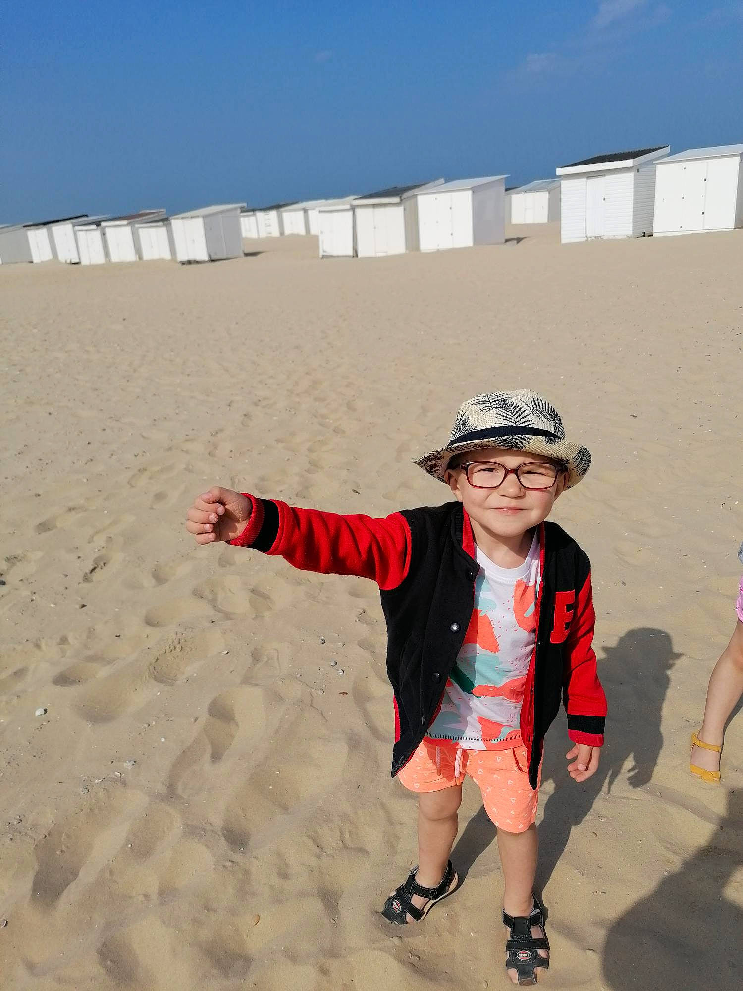 Gabriel participe au concours pour gagner de l'argent avec cette photo : aeolian_landform, azure, beach, body_of_water, eyewear, fun, happy, hat, headgear, headwear, joy, landscape, natural_environment, person, personal_protective_equipment, sand, shorts, sky, summer, sun_hat