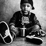 Lucienzo a rejoint le concours — aidez-le/la à gagner de superbes lots ! child, toddler, boy, baseball_cap, jacket, jeans, sneakers, toy_car, sippy_cup, portrait, black_and_white, studio, wooden_floor, seated, serious_expression, direct_gaze, casual_style, close_up, beverage_container, cool_tshirt