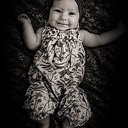 Jadzia joined the competition — help win amazing prizes! baby, child, infant, smiling, portrait, black_and_white, monochrome, lying_down, floral_dress, headband, bow, blanket, patterned_background, outstretched_arms, bare_feet, indoor, studio_photography, happy, face, vintage_style