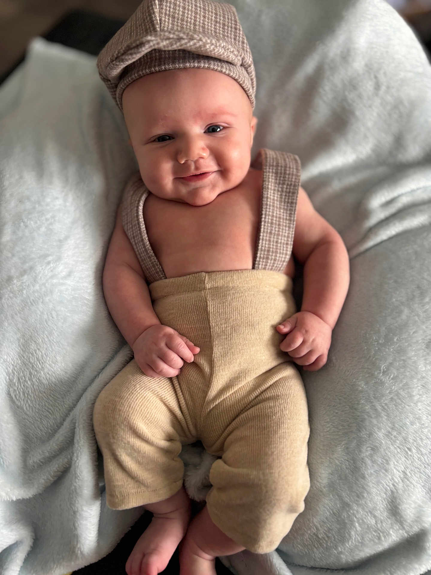 Jaxon joined the competition — help win amazing prizes! baby, infant, smile, face, clothing, hat, blanket, soft_texture, cute, relaxing, indoors, skin, hands, feet, portrait, child, happy, sitting, cozy, apparel