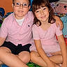 children, boy, girl, smiling, portrait, indoor, bedroom, bed, sitting, hugging, glasses, pink_shirt, pink_dress, shorts, cartoon_bedding, plush_toy, colorful, family, friendship, happy