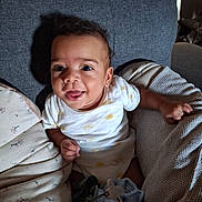 Maël participe au concours pour gagner de l'argent avec cette photo : baby, binky, blanket, child, couch, cozy, eyes, face, hand, indoor, infant, onesie, pacifier, pillow, plush, portrait, smiling, sofa, sun_pattern, tongue_out