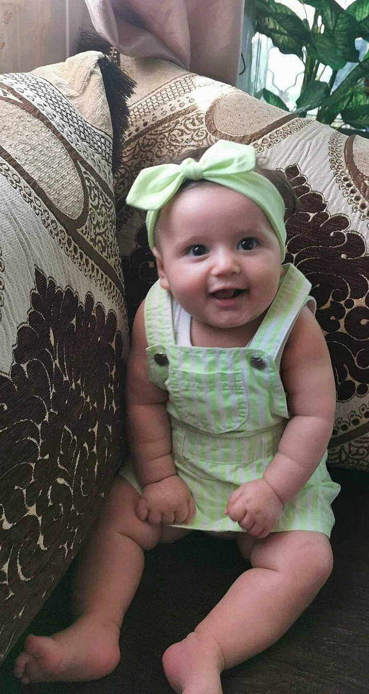 Imen participe au concours pour gagner de l'argent avec cette photo : baby, child, family, fashion_accessory, happy, hat, head, headgear, headwear, person, plant, sitting, skin, smile, sun_hat, toddler