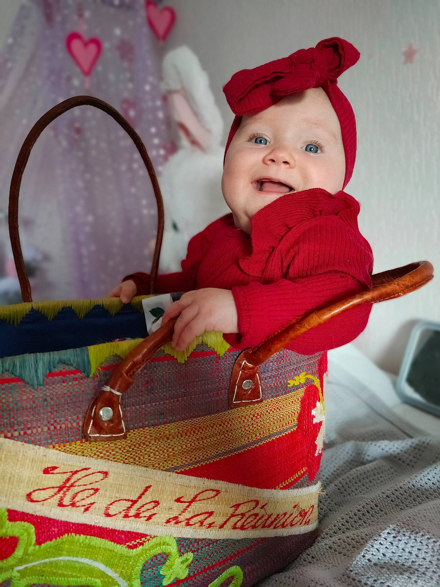 Poëma a rejoint le concours — aidez-le/la à gagner de superbes lots ! baby, baby_products, baby_toddler_clothing, basket, carmine, cheek, child, event, fun, happy, hat, headwear, holiday, pattern, person, product, red, sitting, sleeve, smile