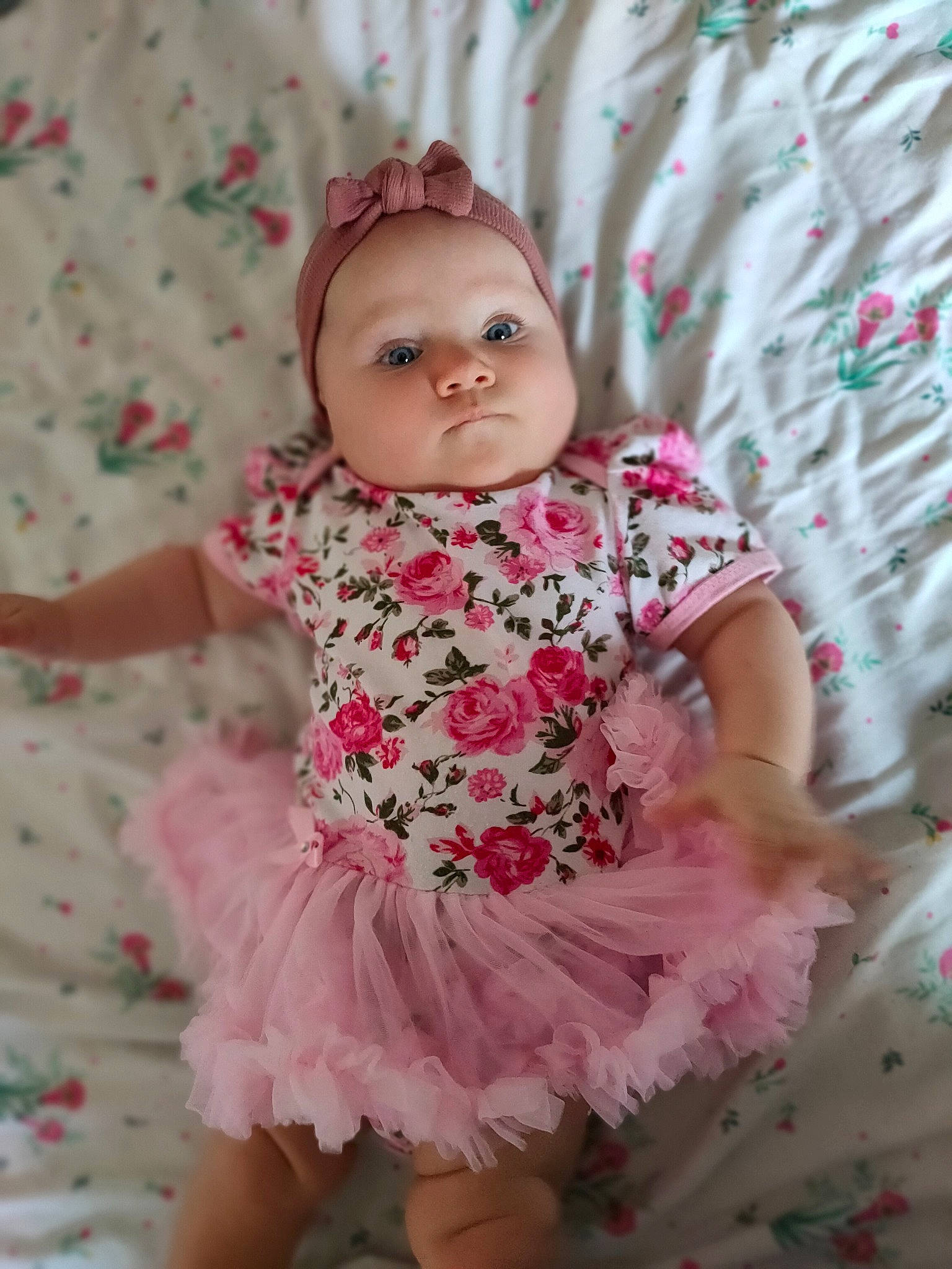 Poëma participe au concours pour gagner de l'argent avec cette photo : baby, baby_toddler_clothing, cheek, child, clothing, day_dress, embellishment, eye, happy, headwear, iris, linens, lip, magenta, pattern, person, petal, pink, skin, sleeve