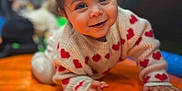 Arya participe au concours pour gagner de l'argent avec cette photo : toddler, child, smiling, crawling, red_hair_ties, heart_pattern, sweater, orange_surface, indoor, play_area, cute, happy, portrait, baby, face, person, young_child, warm_lighting, soft_focus, fun