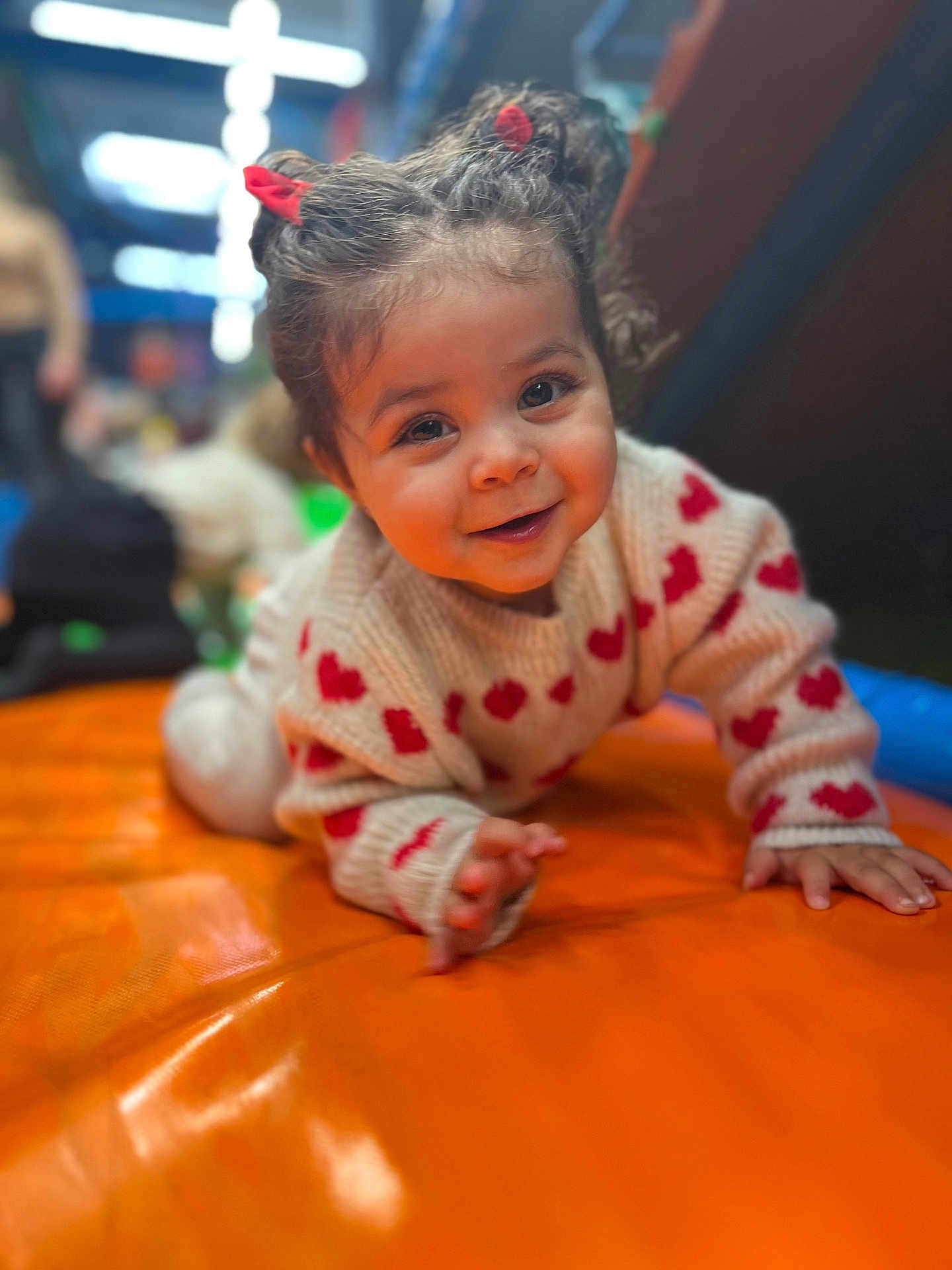 Arya participe au concours pour gagner de l'argent avec cette photo : toddler, child, smiling, crawling, red_hair_ties, heart_pattern, sweater, orange_surface, indoor, play_area, cute, happy, portrait, baby, face, person, young_child, warm_lighting, soft_focus, fun