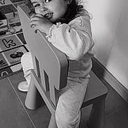 Lonie a rejoint le concours — aidez-le/la à gagner de superbes lots ! child, smiling, chair, indoor, playmat, toy, sneakers, cute, portrait, happy, young, person, floor, clothing, curly_hair, monochrome, toddler, playroom, sitting, cozy