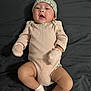 adorable, baby, child, comfortable, cute, expression, floral_pattern, hat, headwear, indoors, infant, lying_down, mittens, newborn, person, pink_clothing, portrait, skin, socks, soft_fabric
