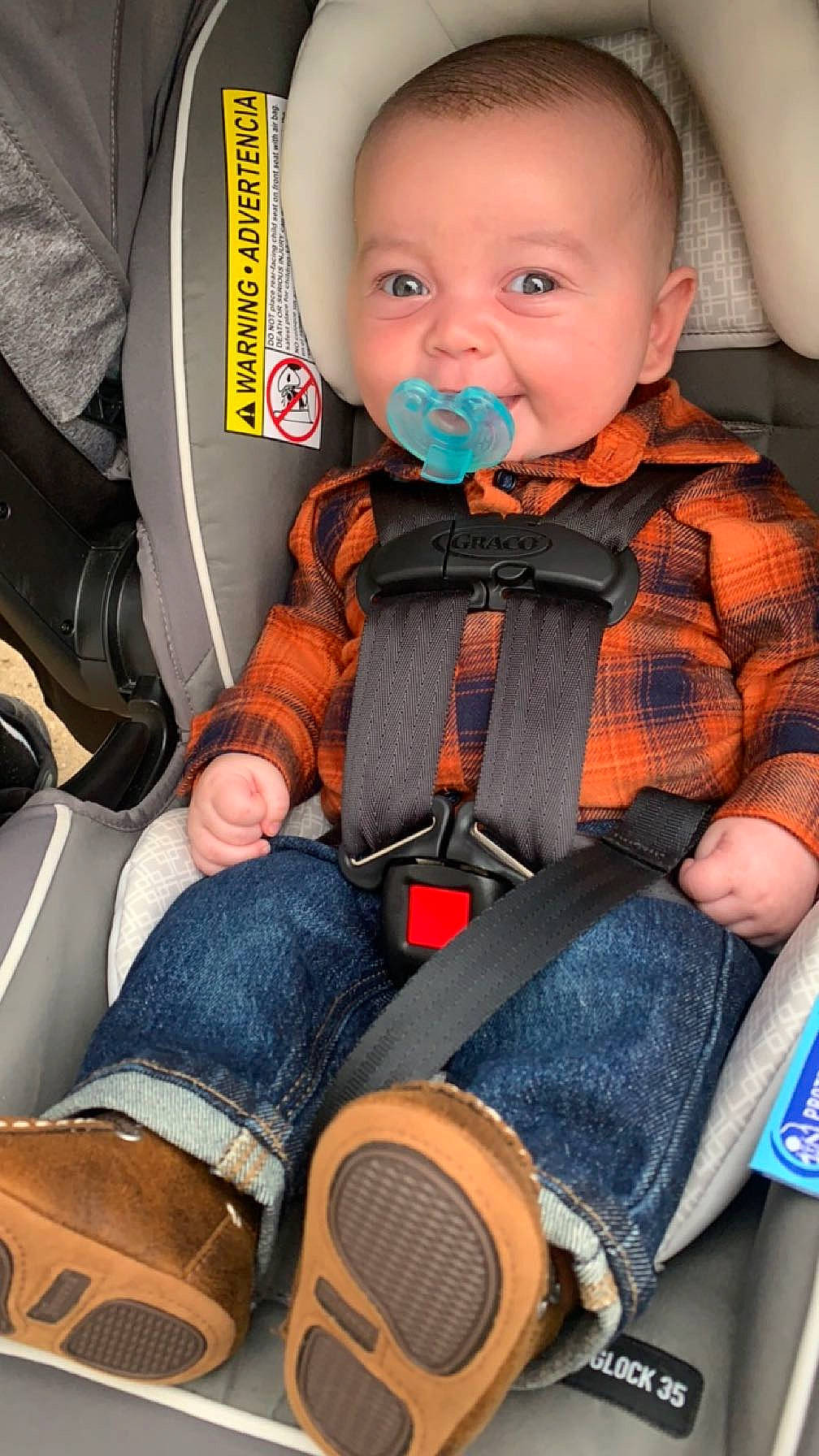 Evan is registered to the contest to win money with this photo: baby, baby_carriage, baby_products, baby_toddler_clothing, car_seat, cheek, child, comfort, human_leg, jeans, knee, motor_vehicle, orange, person, personal_protective_equipment, seat_belt, sitting, skin, thigh, toddler