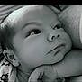 baby, infant, face, closeup, black_and_white, hand, resting, expression, thoughtful, cozy, blanket, portrait, young_child, skin, head, person, cute, sleepy, soft_light, calm