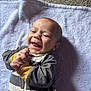 Carter joined the competition — help win amazing prizes! baby, infant, smile, happy, clapping, onesie, striped_clothing, lying_down, towel, soft_texture, indoor, carpet, closeup, child, cute, young, human, portrait, joy, expression