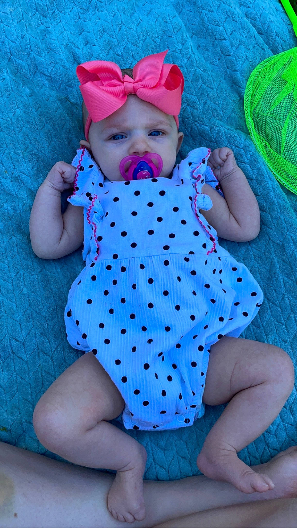 Charlotte is registered to the contest to win money with this photo: aqua, baby, baby_toddler_clothing, cap, child, comfort, electric_blue, green, headwear, human_leg, linens, magenta, pattern, person, pink, purple, skin, sleeve, textile, thigh