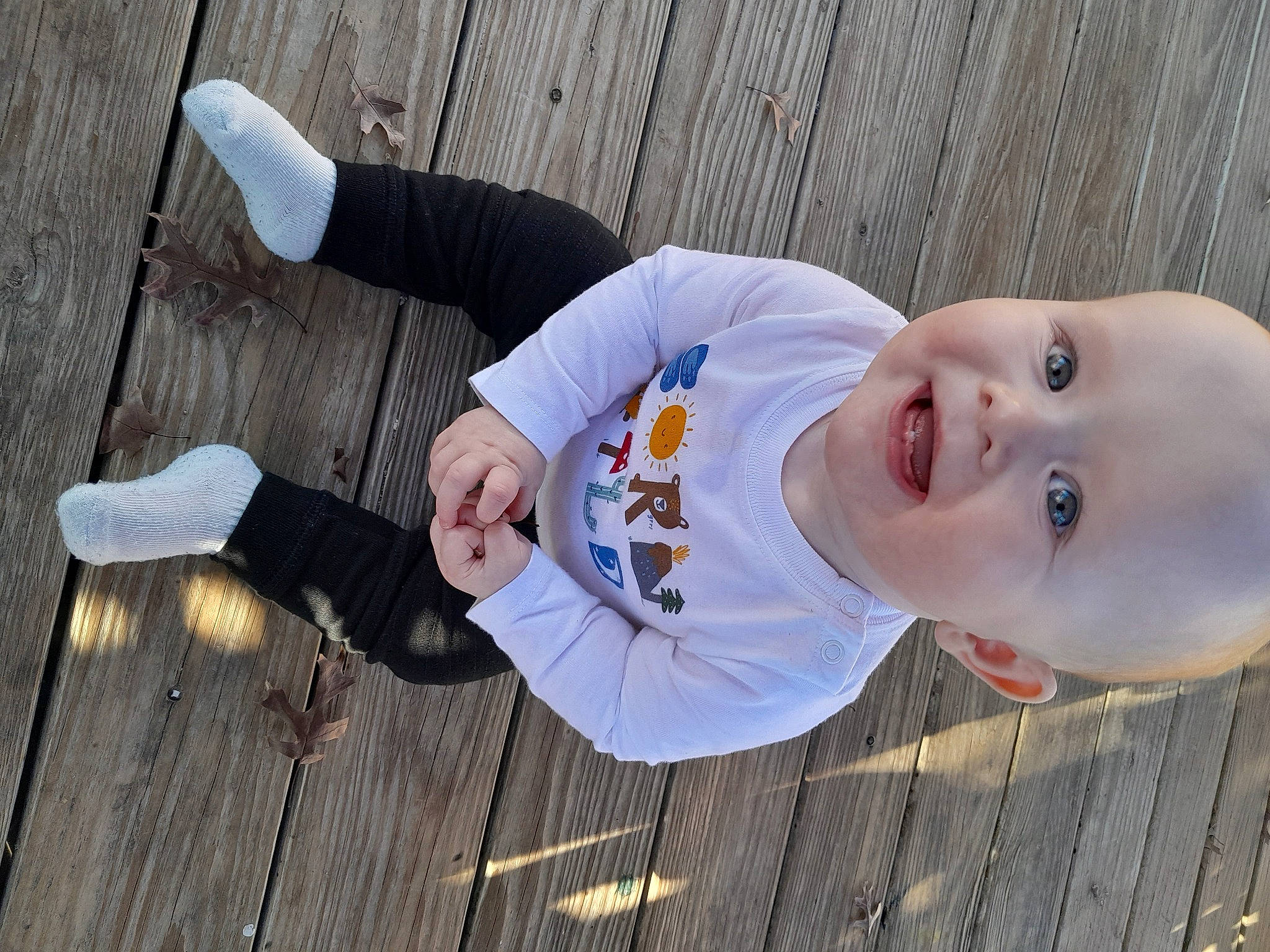 Jamison is registered to the contest to win money with this photo: baby, baby_laughing, baby_toddler_clothing, child, flooring, fun, gesture, grass, happy, hardwood, leisure, pattern, people_in_nature, person, sitting, skin, smile, thumb, toddler, tree