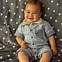baby, child, smiling, sitting, romper, clothing, blanket, polka_dot, gray, cute, happy, infant, portrait, chubby, feet, hand, face, indoors, soft, comfort