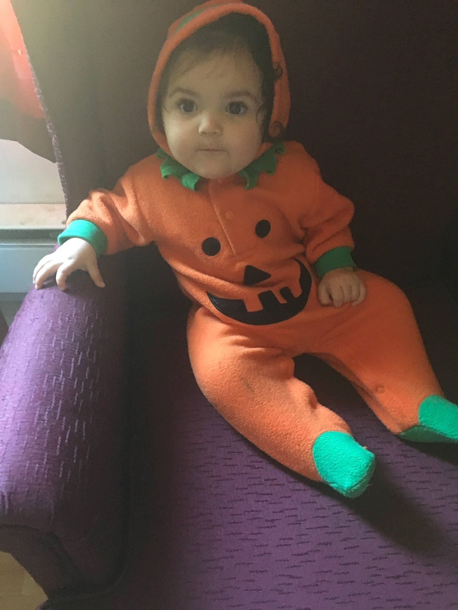 Ana is registered to the contest to win money with this photo: arm, baby, child, costume, face, fictional_character, finger, green, hand, head, joint, neck, person, purple, skin, smile, stuffed_toy, thumb, toddler, toy