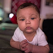 Atreus is registered to the contest to win money with this photo: baby, infant, child, face, hands, white_shirt, lying_down, indoor, portrait, expression, cute, young, skin, head, eyes, mouth, person, human, closeup, focus