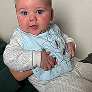 Oliver joined the competition — help win amazing prizes! baby, infant, blue_eyes, bib, pajamas, hand, face, person, child, cute, chubby_cheeks, indoor, holding, clothing, curious, portrait, skin, young, sitting, soft_lighting
