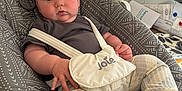 Oliver is registered to the contest to win money with this photo: baby, infant, baby_seat, gray_pattern, clothing, striped_pants, harness, joie, face, blue_eyes, hand, foot, toy, colorful, kitchen, window, sink, counter, furniture, indoor