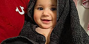 Tanisha joined the competition — help win amazing prizes! adult, baby, bathroom, black_towel, child, closeup, cute, fabric, face, happy, head_covering, holding, indoor, person, portrait, red_shirt, smile, texture, towel, wrapped