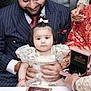 Tanisha is registered to the contest to win money with this photo: baby, child, man, suit, tie, jewelry, rings, bracelet, dress, floral, celebration, hands, portrait, traditional_clothing, table, people, event, happy, family, indoor