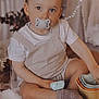 Kassïm participe au concours pour gagner de l'argent avec cette photo : toddler, child, pacifier, sitting, wooden_floor, stacking_cups, socks, shorts, white_shirt, indoor, decor, flowers, curious, baby, cute, young_child, playing, soft_lighting, portrait, home