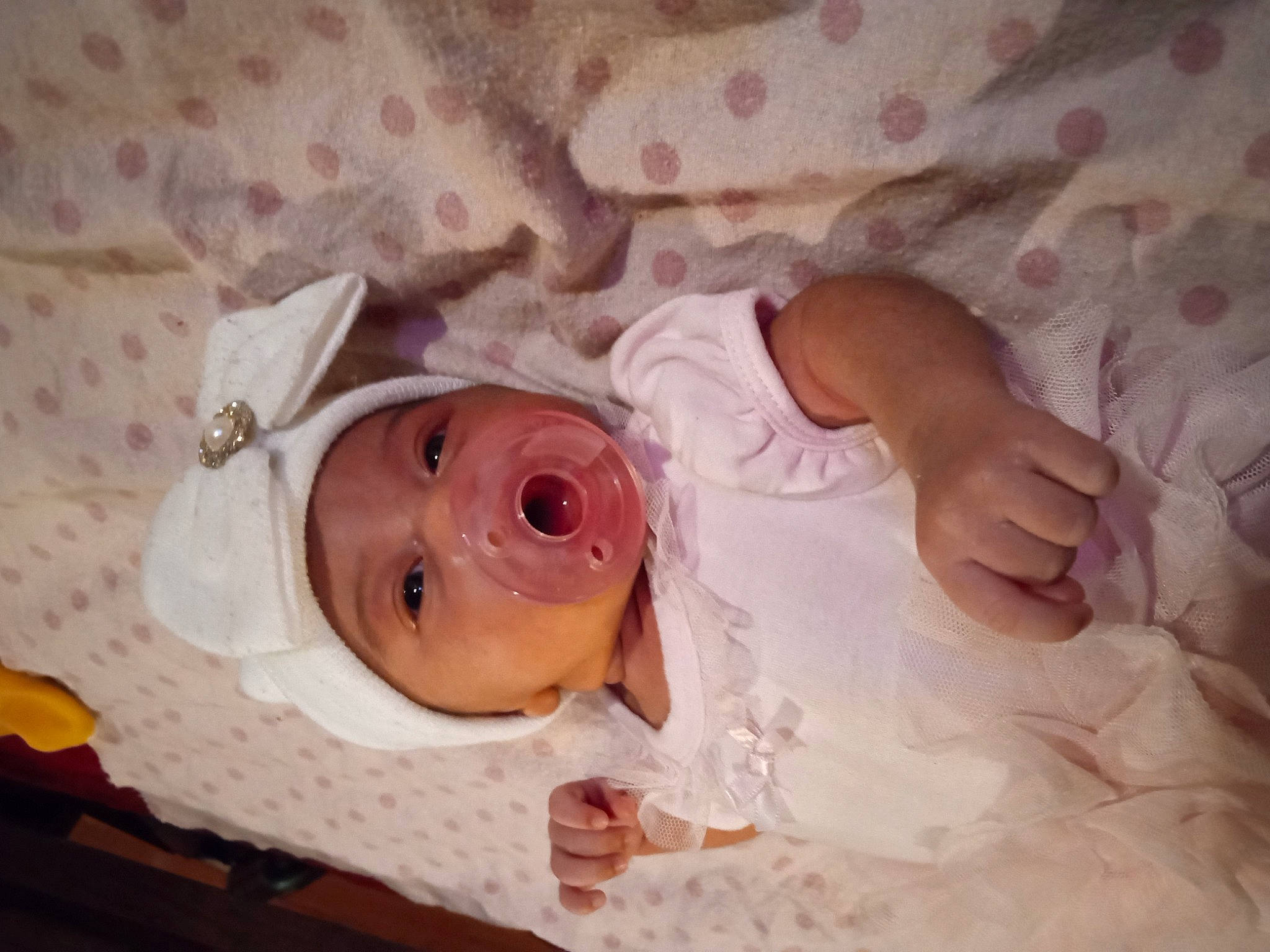 Zaylah is registered to the contest to win money with this photo: baby, baby_products, baby_safety, baby_toddler_clothing, bed, bedding, child, comfort, eye, flower, head, headgear, headwear, human_body, infant_bed, linens, pattern, person, room, skin