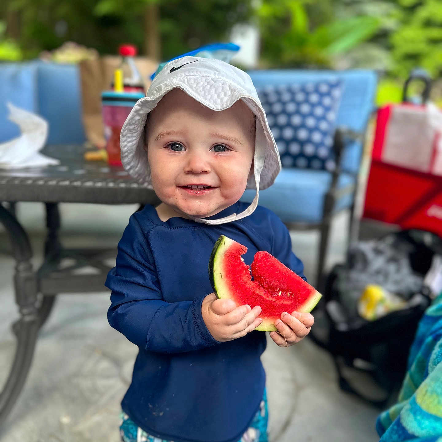 Lincoln is registered to the contest to win money with this photo: baby, chair, clothing, coat, eating, face, food, fruit, furniture, hat, head, melon, person, photography, plant, portrait, produce, shorts, summer, watermelon