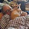 man, dog, sleeping, glasses, blanket, couch, indoor, resting, pet, elderly, relaxing, brown_dog, small_dog, comfort, home, portrait, casual, cozy, content, furniture