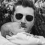 Alina a rejoint le concours — aidez-le/la à gagner de superbes lots ! man, baby, child, sunglasses, holding, tree, outdoor, black_and_white, portrait, face, person, nature, emotion, affection, closeup, parent, family, hands, head, calm
