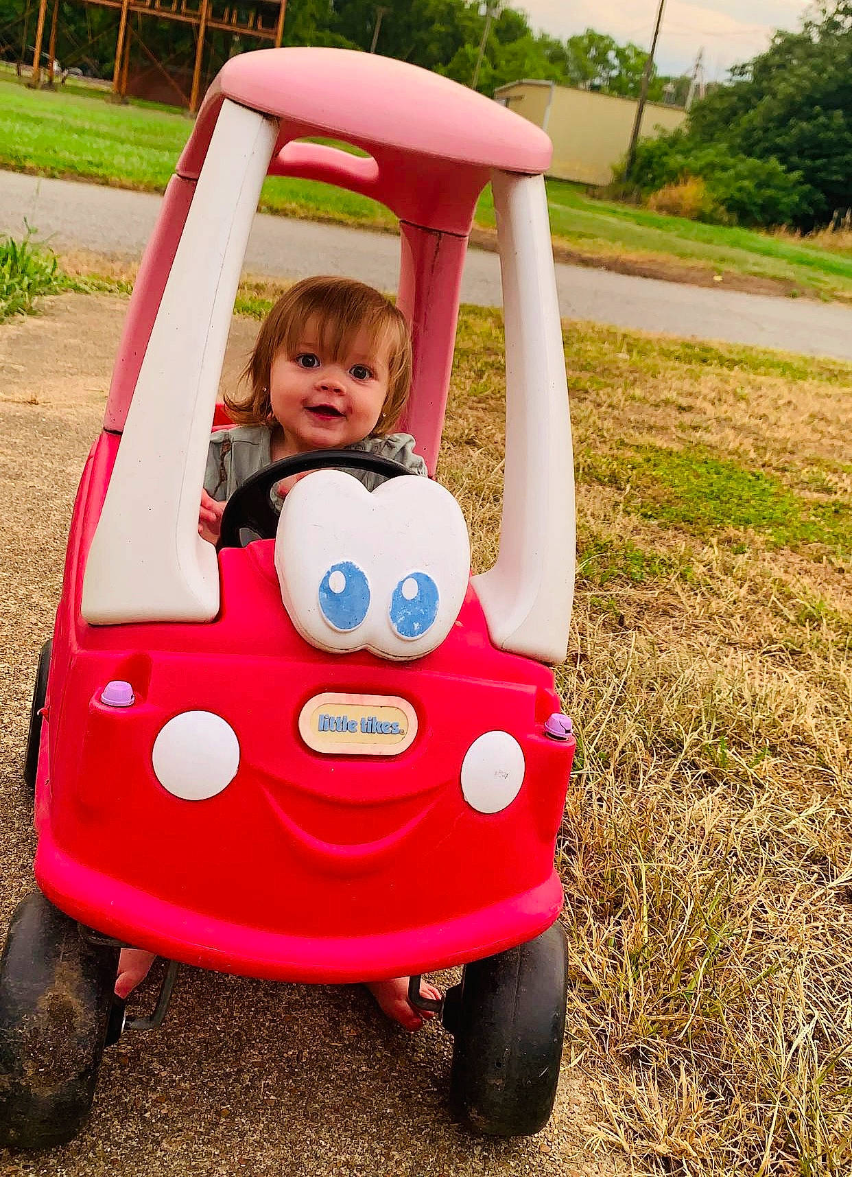 Nataleigh is registered to the contest to win money with this photo: automotive_design, automotive_exterior, automotive_tire, baby_toddler_clothing, bumper, car, grass, happy, jeans, motor_vehicle, person, plant, recreation, riding_toy, smile, tire, toddler, tree, vehicle, vehicle_door