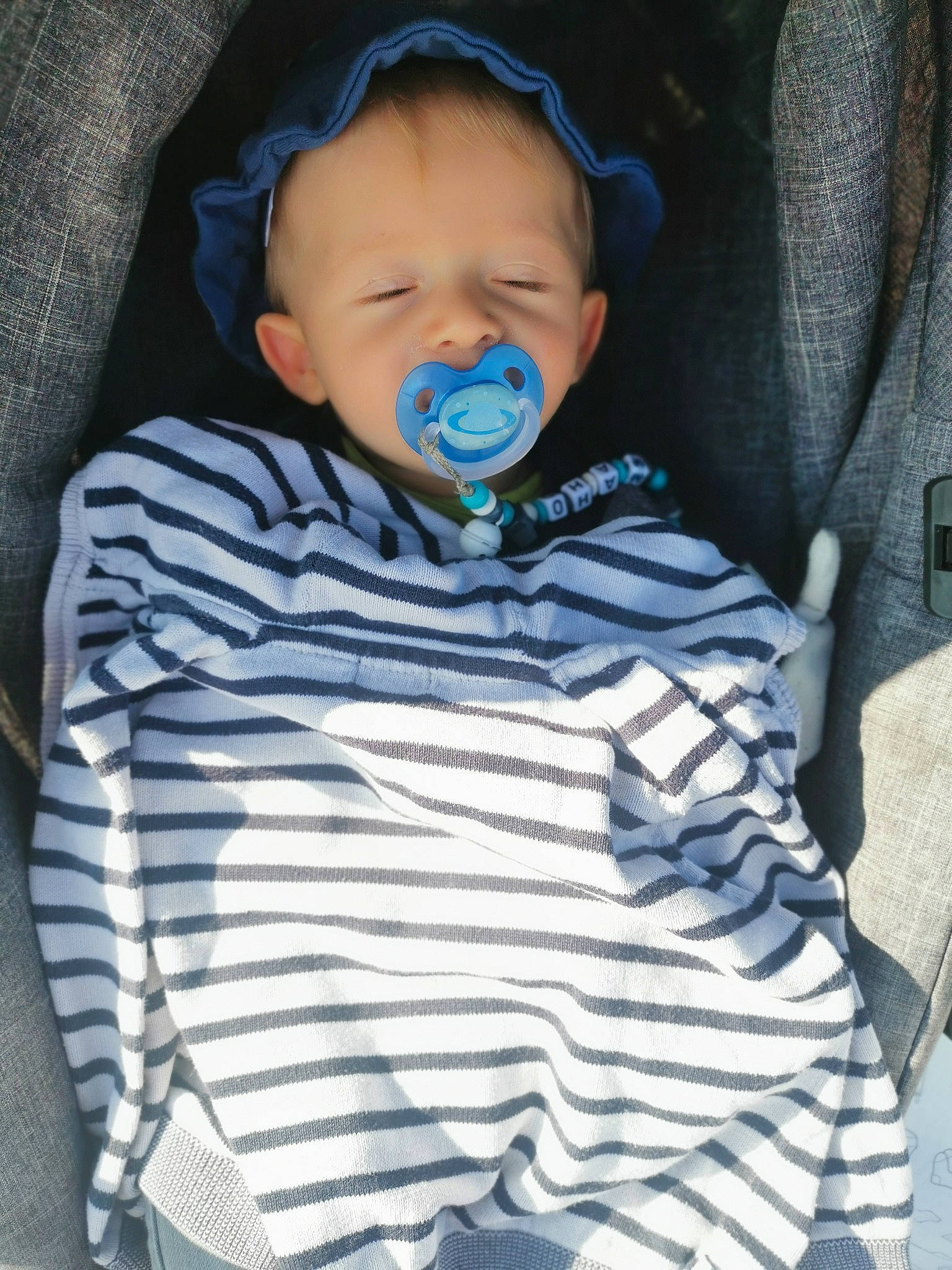 Maho participe au concours pour gagner de l'argent avec cette photo : baby, baby_products, baby_toddler_clothing, blue, child, electronic_device, facial_expression, outerwear, person, product, smile, toddler