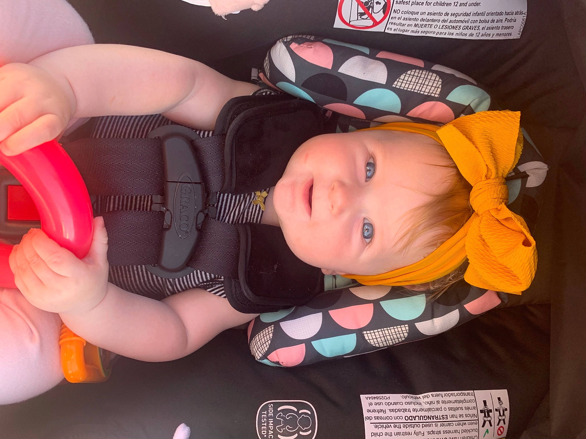 Zaya is registered to the contest to win money with this photo: baby, baby_playing_with_toys, baby_products, baby_toddler_clothing, beauty, cheek, child, eyelash, fashion_accessory, finger, gesture, human_body, material_property, nail, orange, person, pink, product, thumb, toddler