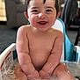 baby, child, bath, bathtub, water, bubbles, smiling, happy, cute, toddler, baby_bath_seat, bare_torso, chubby_arms, close_up, indoor, furniture, toy, wet_skin, portrait, suds