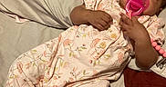 Roslynn joined the competition — help win amazing prizes! baby, infant, sleeping, pacifier, bed, pillow, floral_pajamas, pink_clothing, socks, portrait, indoors, bedroom, resting, relaxed, cozy, dark_skin, curly_hair, lying_down, blanket, photography