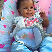 Roslynn is registered to the contest to win money with this photo: baby, infant, child, smiling, sitting, baby_seat, stroller, outdoor, grass, portrait, face, hands, feet, socks, clothing, tissue, disney, minnie_mouse, pink, playful