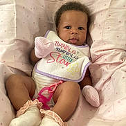Roslynn joined the competition — help win amazing prizes! baby, infant, child, portrait, lying_down, blanket, pink, polka_dots, bib, text, star, socks, pacifier, onesie, bed, indoor, face, eyes, cute, newborn