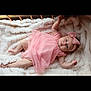 baby, infant, pink_dress, headband, bow, blanket, crib, sleepwear, lying_down, cute, child, soft_texture, cozy, indoor, portrait, one_person, newborn, skin, hands, feet