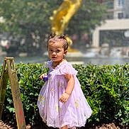Basma joined the competition — help win amazing prizes! ball, caution_sign, child, curly_hair, dress, golden, greenery, outdoor, plants, portrait, purple, sandals, shoes, sidewalk, statue, summer, sunlight, toddler, wet_floor_sign, young_child