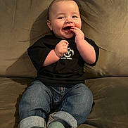 Hugo joined the competition — help win amazing prizes! baby, black_tshirt, casual_clothing, child, couch, cute, face, feet, happy, home, indoor, infant, jeans, person, portrait, relaxed, sitting, smiling, socks, young_child