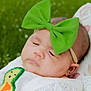 Layla joined the competition — help win amazing prizes! baby, infant, sleeping, green_bow, headband, white_clothing, embroidered_patch, cushion, floral_pattern, outdoor, grass, closeup, portrait, cute, peaceful, soft_texture, child, face, resting, head