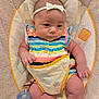 baby, infant, headband, pacifier, colorful_clothing, striped_dress, baby_seat, cushion, soft_texture, chubby_cheeks, arm, leg, hand, foot, indoor, cute, child, person, young, comfort