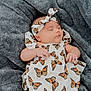 baby, infant, sleeping, butterfly_pattern, headband, dress, blanket, gray_blanket, outdoor, grass, soft_texture, peaceful, cute, newborn, person, child, portrait, resting, fashion, toddler