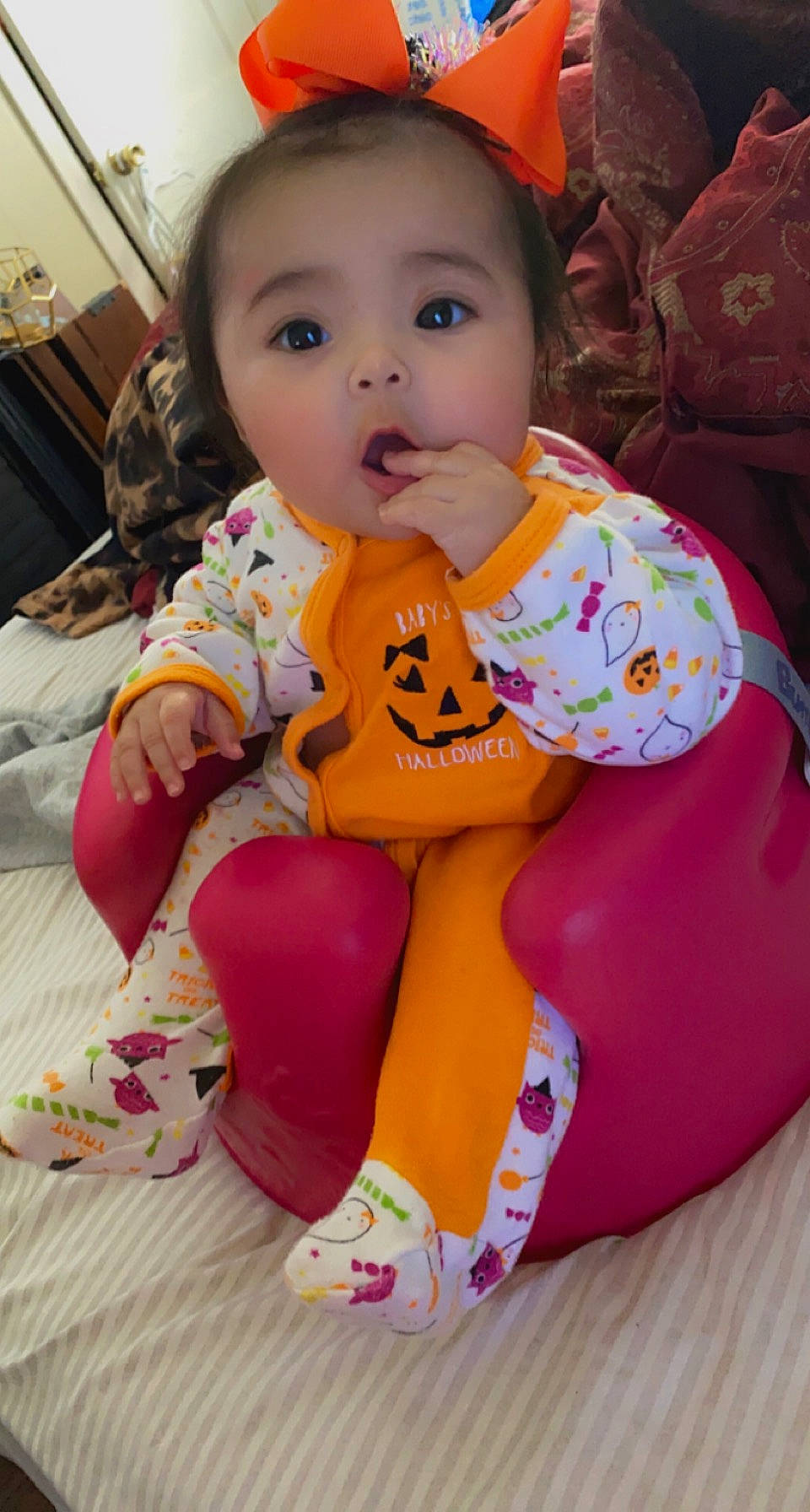Luna is registered to the contest to win money with this photo: baby, baby_toddler_clothing, bib, cheek, child, comfort, dress, eye, face, fun, happy, head, lap, orange, person, pink, sitting, skin, sleeve, toddler