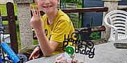 Maël participe au concours pour gagner de l'argent avec cette photo : bicycle, birthday_cake, blossom, boy, celebration, chair, child, chocolate_cake, daytime, fence, garden, happy, nature, outdoor, person, smiling, spring, table, tree, yellow_shirt