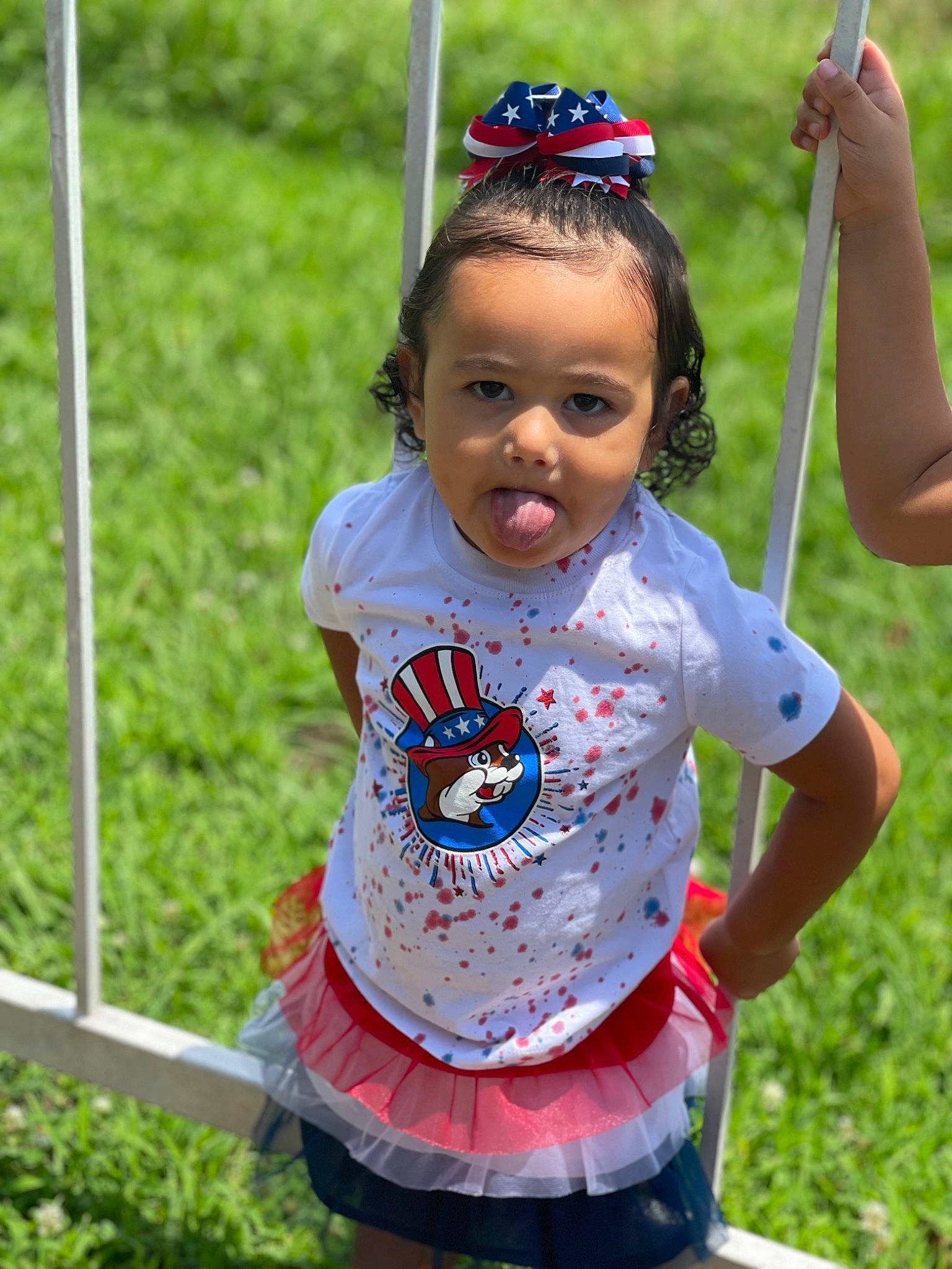 Lillyanna is registered to the contest to win money with this photo: baby_toddler_clothing, child, eye, face, fun, grass, hair, hairstyle, happy, head, leisure, pattern, people_in_nature, person, pole, public_space, recreation, sleeve, summer, swing