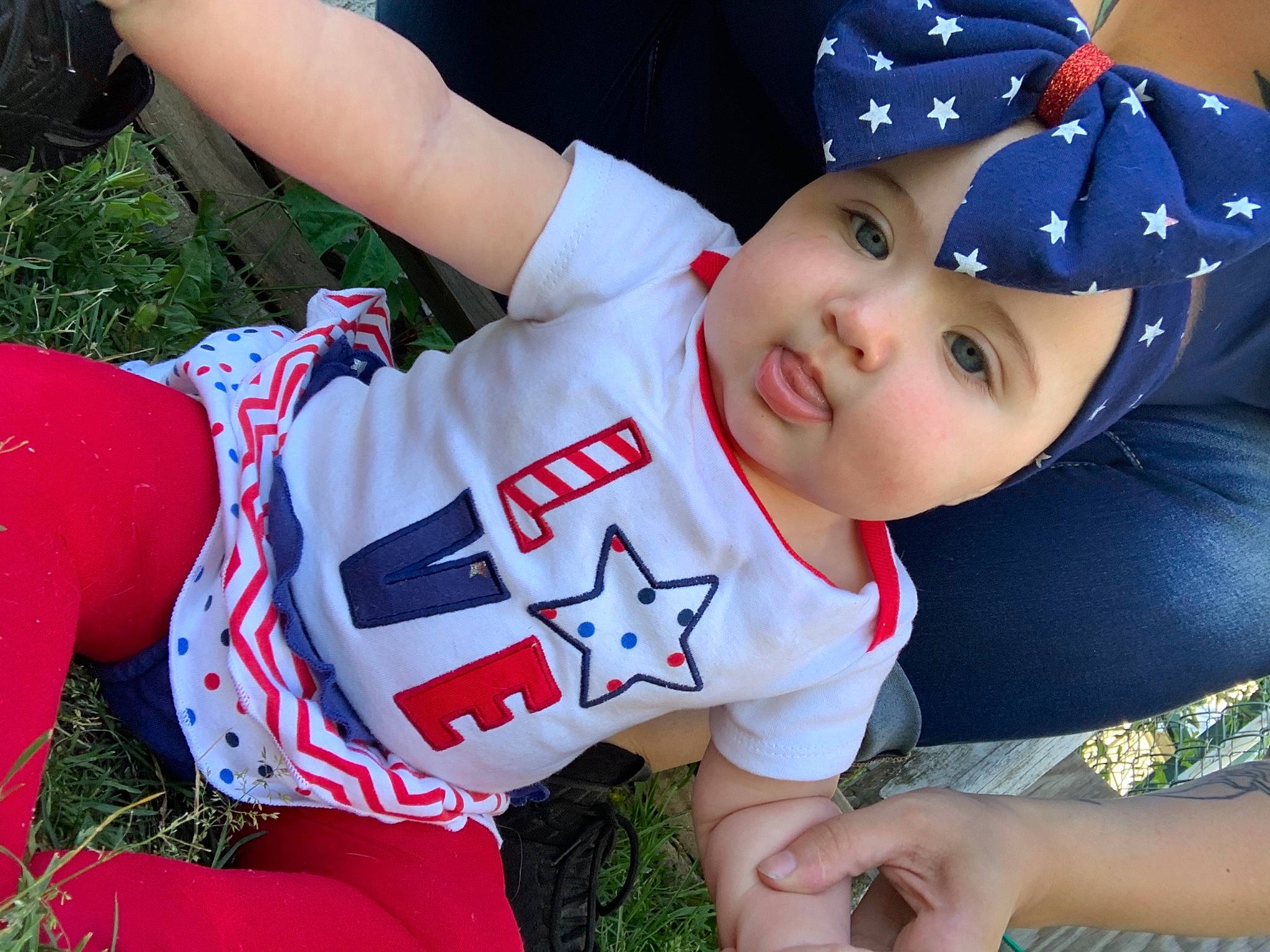 Shelby is registered to the contest to win money with this photo: baseball_cap, cap, child, cool, finger, fun, grass, hand, happy, hat, headgear, headwear, human_leg, leisure, person, plant, recreation, red, smile, t_shirt